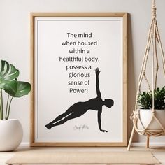 a poster with a woman doing yoga poses on it next to a potted plant