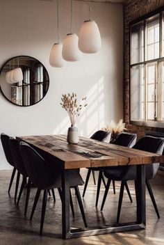 a dining room table with chairs and a vase on it in front of a window