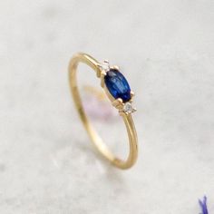 Blue Sapphire 14K Gold Ring-Oval Sapphire Stone-Dainty Promise Ring-Minimalist-Delicate Sapphire Ring with Diamonds-September Birthstone A royal ring for a royal lady. A three stone setting, royal blue oval sapphire stone that is nestled ever so gently in between two round 0.016ct diamond stones. This ring can make the perfect engagement ring to symbolize your love for a classic yet minimal lady or just a little treat to yourself. ›› Item Details: › Made to Order › Gold Kt: 14K (also available i Elegant Sapphire Ring With Oval Cabochon, Elegant Oval Cabochon Sapphire Promise Ring, Elegant Oval Sapphire Birthstone Ring, Elegant Sapphire Birthstone Ring In Oval Shape, Dainty Oval Sapphire Ring For Formal Occasions, Oval Sapphire Birthstone Ring, Elegant Sapphire Oval Cabochon Rings, Elegant Blue Sapphire Oval Cabochon Ring, Elegant Blue Oval Cabochon Sapphire Ring