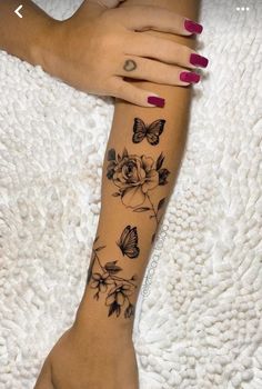 a woman's arm with flowers and butterflies tattooed on the left side of her body