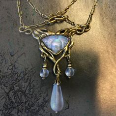 "True to the aesthetic that flourished on the eve of the 20th century, we present this necklace in the Art Nouveau style. A delicate figaro chain forms the perfect silhouette to suspend the confluence of sinuous vines set with an art glass maiden's face, a silhouette of Belle Epoque. This element and the beads are aurora satin glass, which reflect light in soft, iridescent hues. Necklace is finished in burnished bronze. Signed and copyrighted Sweet Romance. Free shipping. Arrives ready to gift. Art Noveau Jewellery, Art Nouveau Clothing, Art Nouveau Jewelry Vintage, Vintage Necklace Antiques, Art Nouveau Fashion, Art Nouveau Earrings, Art Nouveau Necklaces, Art Glass Jewelry, Aqua Earrings