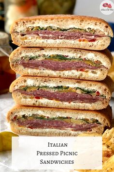 a stack of sandwiches sitting on top of a table next to some potato wedges