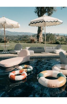 an inflatable pool with lounge chairs and umbrellas next to the swimming pool