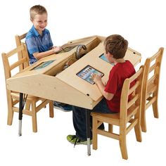 two young boys sitting at a table with pictures on it