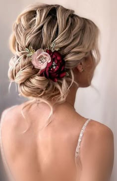 the back of a woman's head wearing a flower in her hair and braid