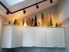 christmas trees are lined up on top of the cabinets