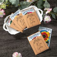 four cards with flowers on them sitting next to each other in front of a bowl