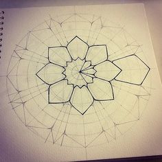 a drawing of a flower in the middle of it's petals is shown on top of a notebook