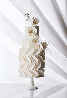 a three tiered cake with white flowers on top