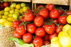 tomatoes and lemons are in baskets on display