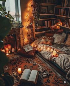 a bed with books and candles on it in front of a book shelf filled with books