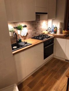 a kitchen with wooden floors and white cabinets