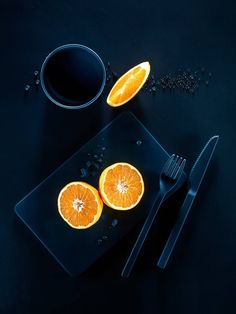 two slices of orange sitting on top of a black plate