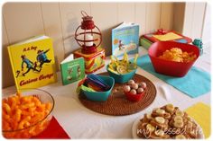 the table is set up with various foods and books for children's birthday party