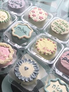 there are many cupcakes in the plastic trays on the display table together