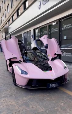 a pink sports car parked in front of a building