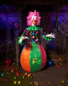 a creepy clown sitting on top of a colorful ball