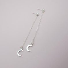 SOLID STERLING SILVER EARRINGSThese celestial earrings make a wonderful gift. The real sterling ear studs are adorned with a tiny moon that dangles elegantly on sterling silver chain. Comes in a gift box, perfect for gift giving. Total earring length is approximately 2 3/4 inches long. ALSO AVAILABLE IN A STAR DESIGN OR MOON/STAR COMBO Sterling Silver Celestial Earrings For Gift, Dainty Moon Phase Earrings, Minimalist Silver Moon Phase Earrings, Dainty Moon-shaped Moon Phase Earrings, Dainty Moon-shaped Earrings, Minimalist Moon Shaped Single Earring, Silver Moon Charm Earrings For Everyday, Minimalist Moon Charm Drop Earrings, Sterling Silver Moon Charm Earrings For Everyday