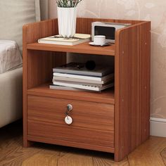 a wooden nightstand with two drawers and a plant on top