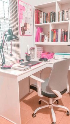 a white desk topped with a laptop computer next to a book shelf filled with books