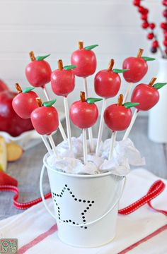 a cup filled with cherries sitting on top of a table