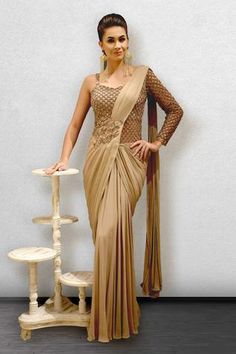 a woman in a beige sari posing for the camera