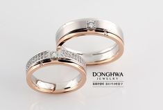 two white and rose gold wedding rings with diamonds on each side, set against a plain background