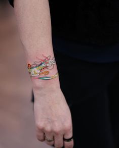 a woman's arm with a tattoo on it and a wristband in the shape of a dragon