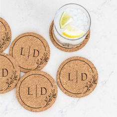 four cork coasters with the word lid on them next to a drink glass and lemon wedge