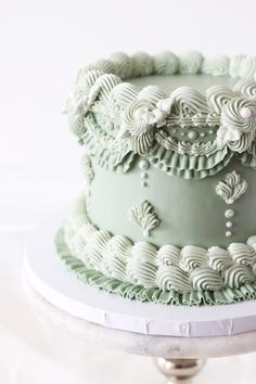 there is a green cake with white icing on the top and bottom tiers