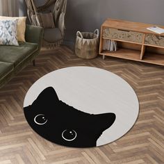 a black cat with big eyes on a white round rug in a living room area