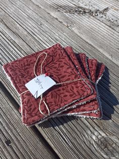 three pieces of red fabric sitting on top of a wooden table next to each other