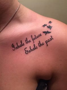 the back of a woman's shoulder with birds on it and words written in cursive ink