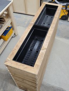 a large wooden box sitting on top of a floor next to a workbench