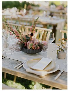 the table is set with plates and place settings for an outdoor dinner party or celebration