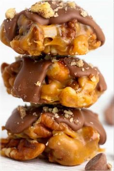 three pieces of chocolate covered pretzels stacked on top of each other with nuts