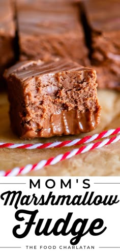 two pieces of brownie sitting on top of a wooden cutting board next to a red and white striped straw