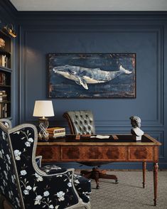 a desk with a chair and lamp in front of a whale painting on the wall