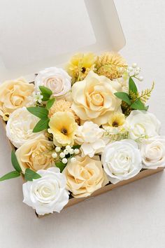 a bouquet of white and yellow flowers in a box