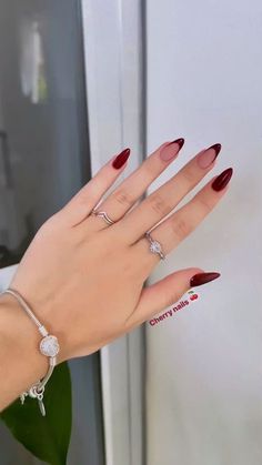 a woman's hand with red and white manicures holding onto a refrigerator