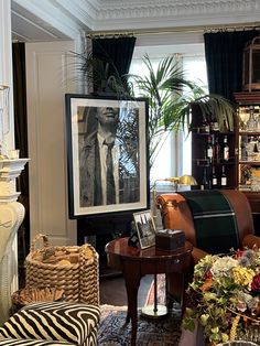 a living room filled with furniture and a painting on the wall above a fire place