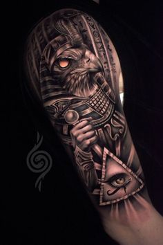 a man's arm with tattoos on it and an eye in the middle, holding a