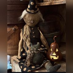 a scarecrow doll sitting next to a pumpkin