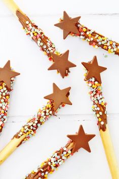 chocolate stars and sprinkles are on top of the wooden skewers