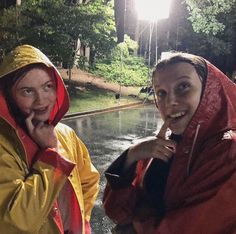 two women standing next to each other in the rain