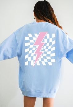 Get Obsessed with the Checkered Aesthetic with this cute Lightning Bolt Sweatshirt! This Preppy Sweatshirt is super comfy! Size up for a Trendy Oversized Look! ♥ Hello and Welcome to Meaningful Tees Shop! ♥ Printed on the most popular Unisex Sweatshirt, the Gildan 18000 is 50% Cotton / 50% Poly. The soft fleece lining makes it super Comfy and is sure to become your new favorite! ♥ All of our items are made one at a time with care for each customer : ) ♥ Please allow 3-7 BUSINESS days (usually 3-5) for your item to be created PLUS shipping time via USPS ♥ This Unisex Sweatshirt fits like a Men's on Women, but is not overly large. ♥ For a RELAXED FIT, your usual size will typically work, but please consult the Size Chart in the Listing Photos ♥ For an OVERSIZED FIT, size up 1, 2 or 3 Sizes! Vsco Crew Neck Sweatshirt For Streetwear, Trendy Blue Sweatshirt With Graphic Print, Trendy Blue Graphic Print Sweatshirt, Spring Grunge Crew Neck Sweatshirt, 90s Inspired Blue Tops With Letter Print, Vsco Crew Neck Sweatshirt In Relaxed Fit, 90s Inspired Crew Neck Top For Fall, White Grunge Crew Neck Sweatshirt, Vsco Style Cotton Crew Neck Top