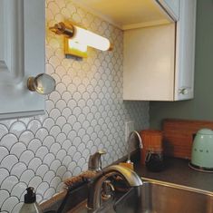 a kitchen sink with a faucet and soap dispenser next to it