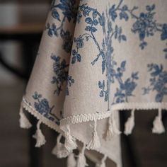 a blue and white table cloth with tassels hanging from it's edge