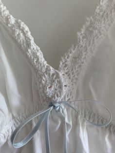 This adorable cotton babydoll top by Victoria's Secret is pure white with light blue now trim and crochet detail!  Super cute as a top over jeans or as a nightgown top or short chemise.  Elastic at back for fit - front has triangle cups and V neck bodice  Straps adjust Tagged size small  Bust flat at back is 12 inches stretching out to 18 inches at the back.  Length as shown is 28 inches  Super comfy for hot weather and summer nights Straps are faintly yellowing. No other issues.  Final sale. No White Cotton V-neck Sleepwear, Summer V-neck Sleepwear With Delicate Lace, Delicate Lace V-neck Sleepwear For Summer, Summer Lace Bedtime Tops, Feminine Cotton Crochet Top With Crochet Trim, Cotton V-neck Top For Bedtime, Delicate White Tops For Summer, Delicate White Summer Tops, Cotton Camisole Top With Crochet Trim