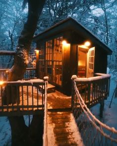 a small cabin is lit up in the snow